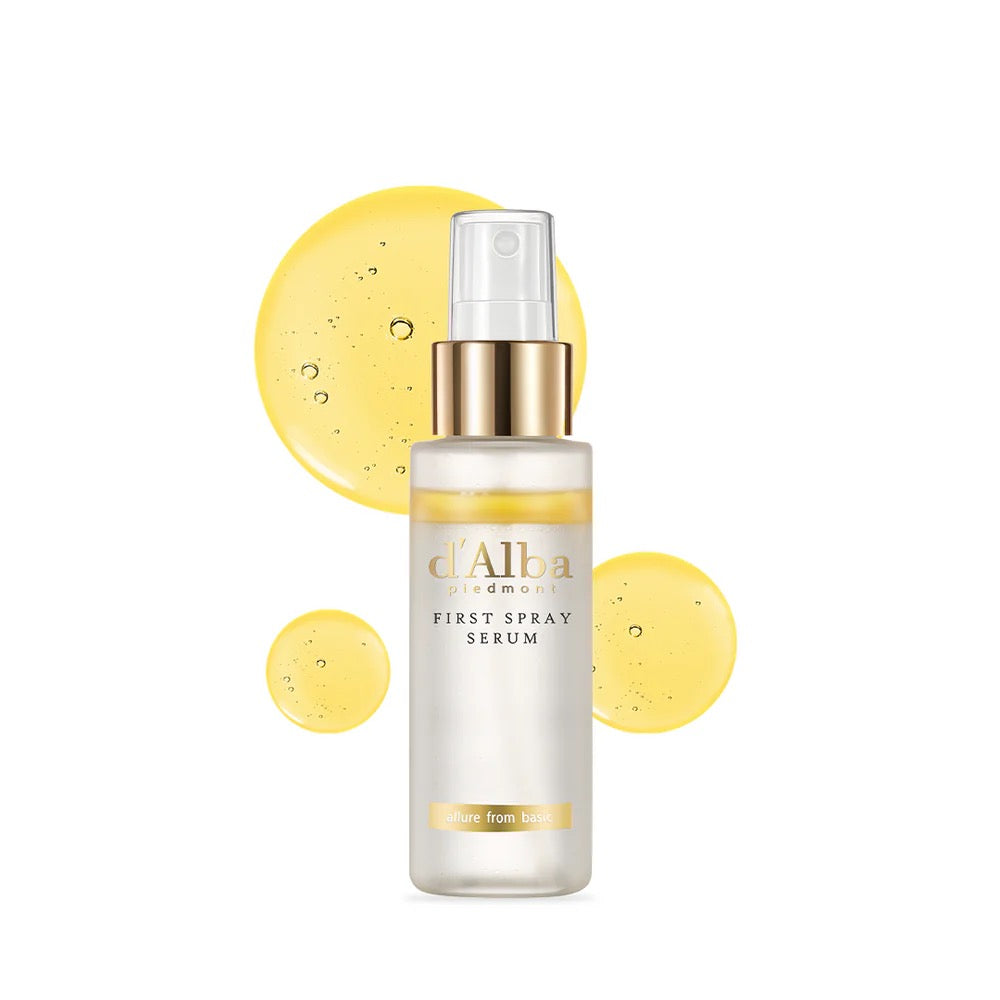 d'Alba first spray serum bottle with yellow droplets on a white background