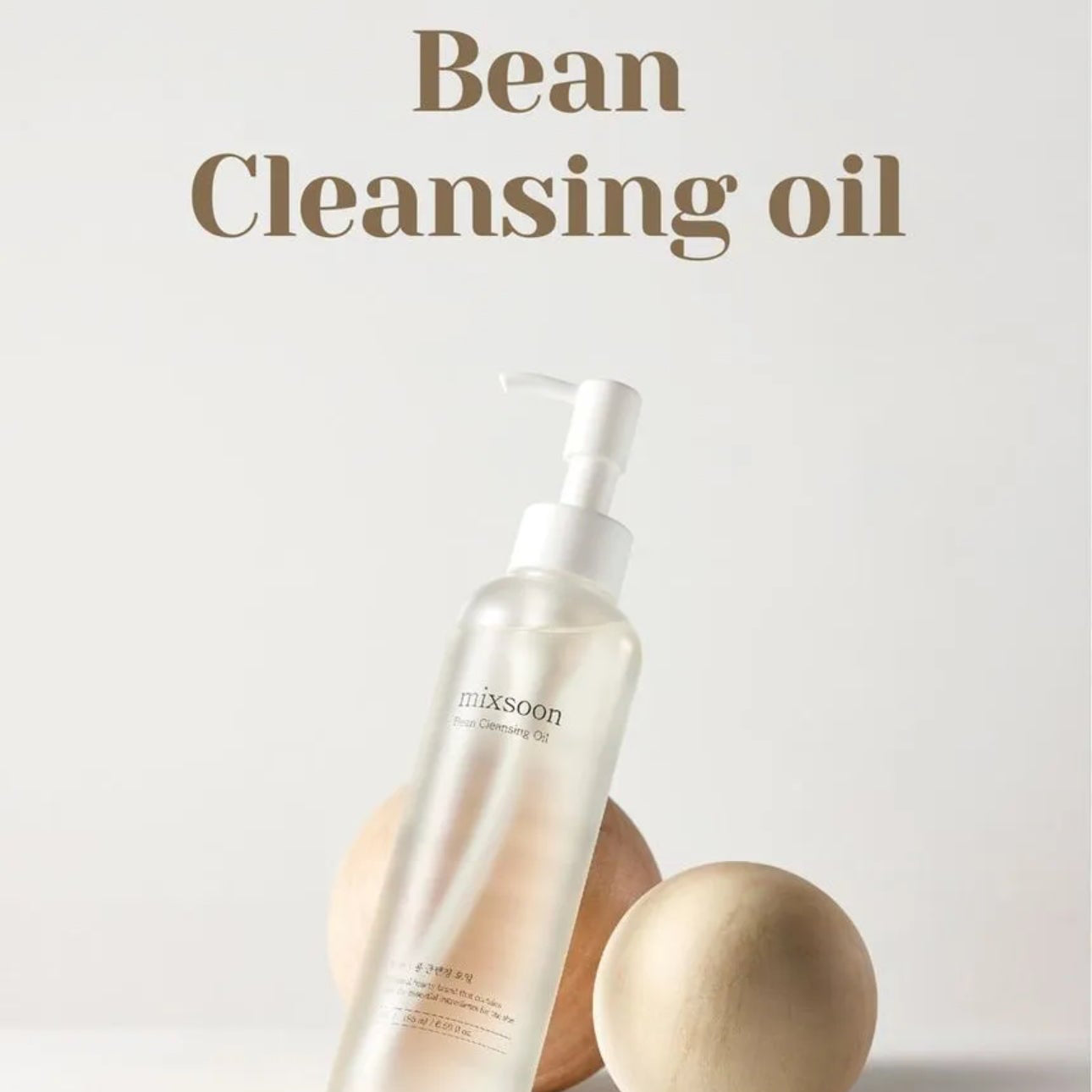 Bean cleansing oil bottle with wooden applicators on a light gray background