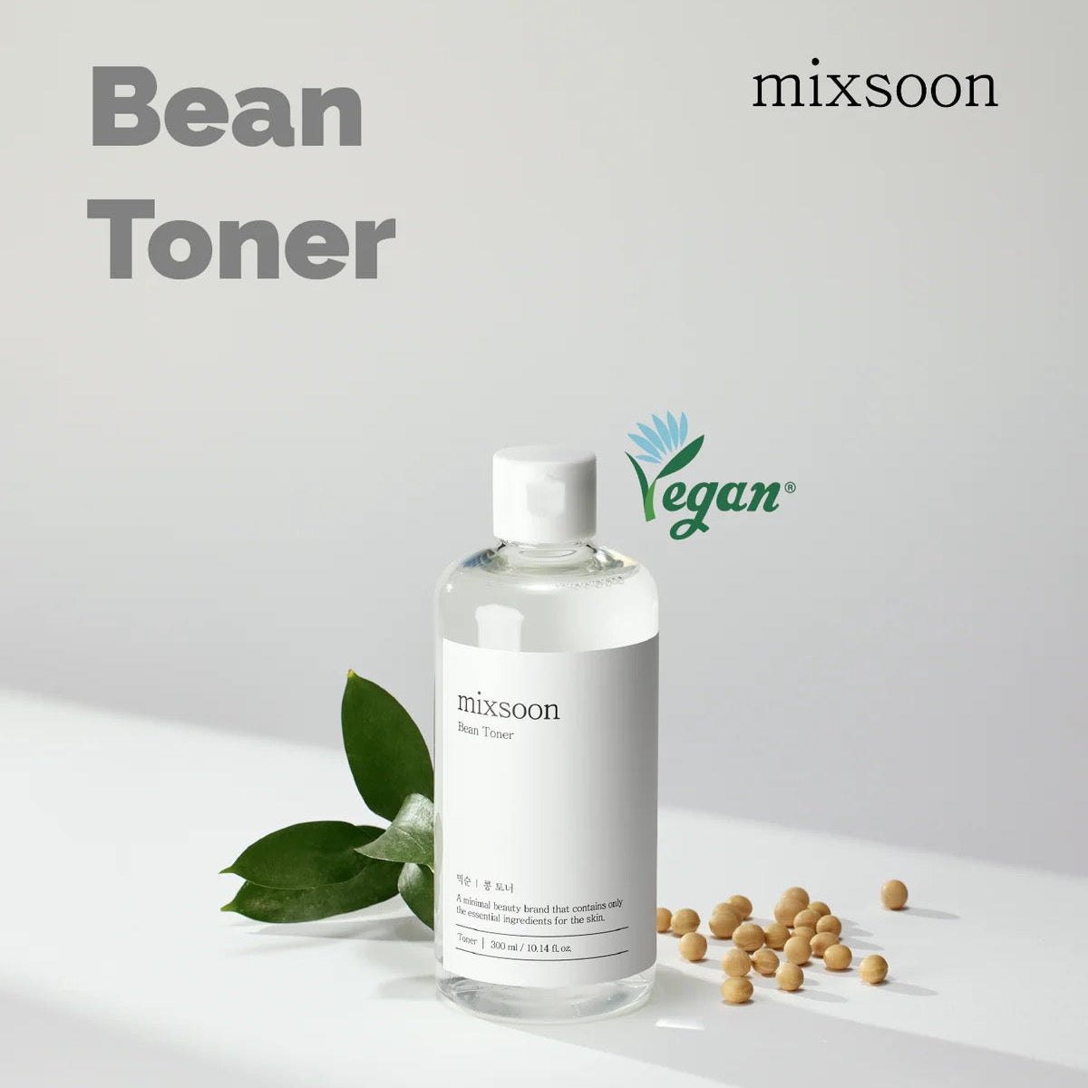 Bottle of mixsoon Bean Toner with leaves and beans on a light background