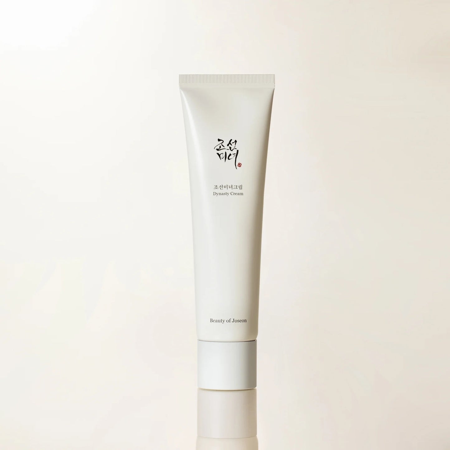 Skincare cream tube with brand logo on a light beige background