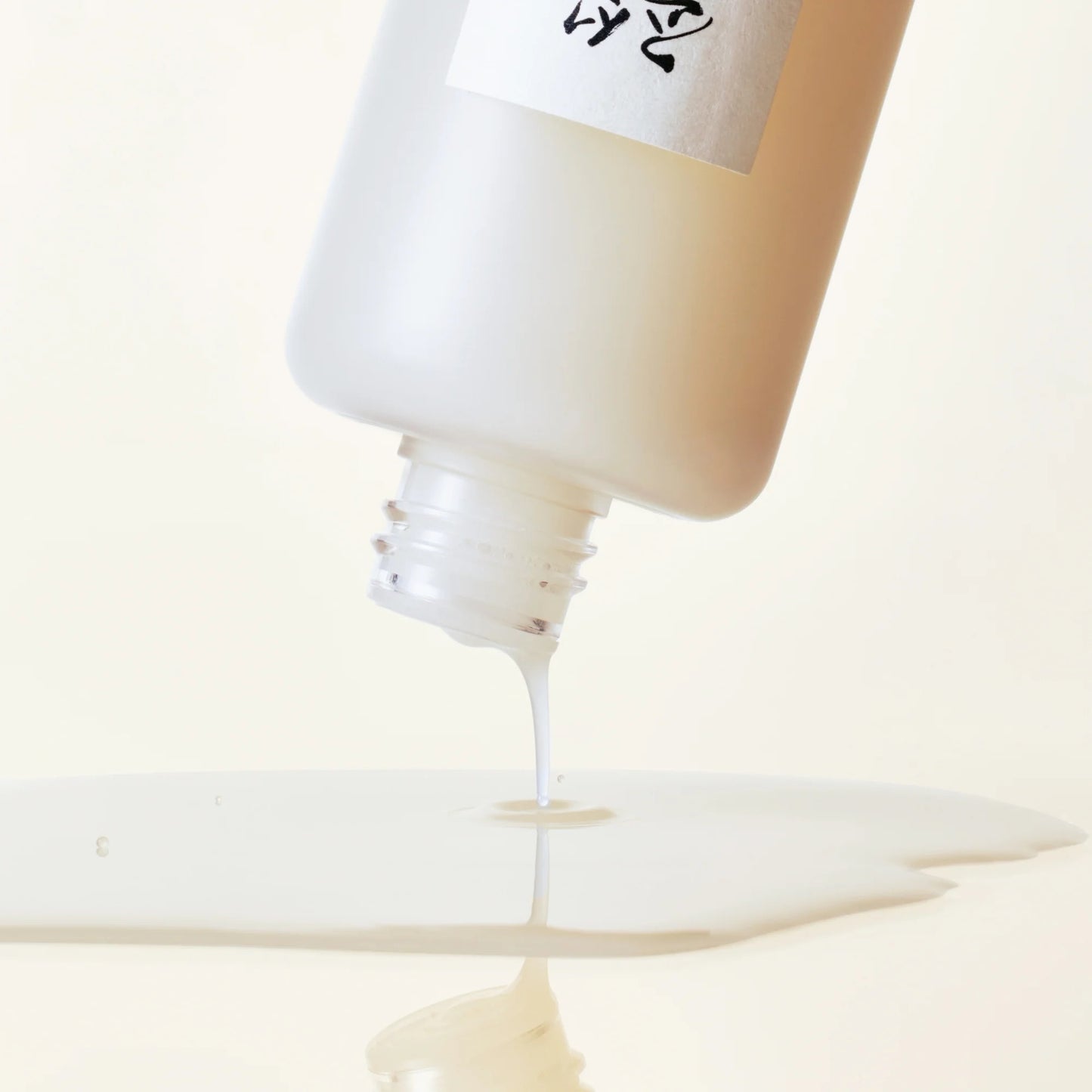 Close-up of a bottle cap being removed from a tube, with a brand name visible.