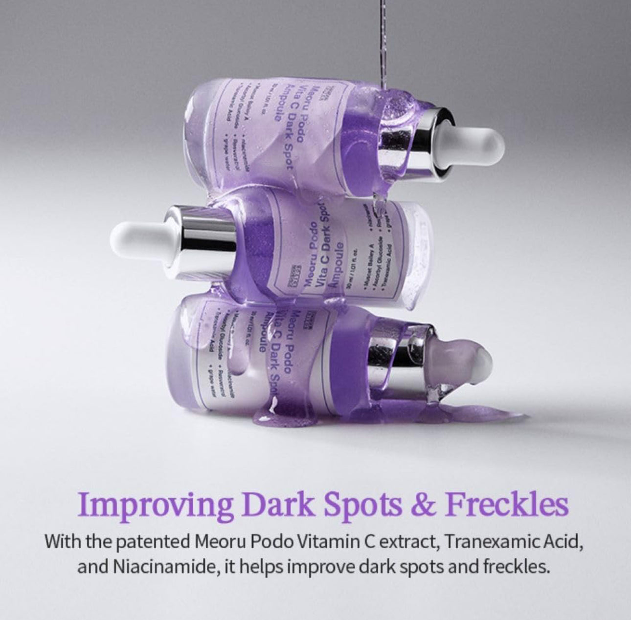 Three purple skincare serum bottles with droppers on a gray background, featuring text about improving dark spots and freckles.
