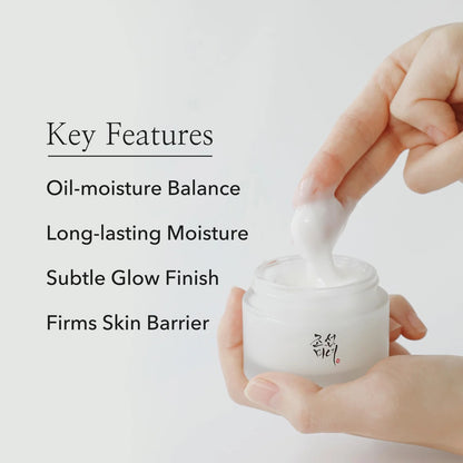 Hand holding a jar of cream with text highlighting key features on a light background