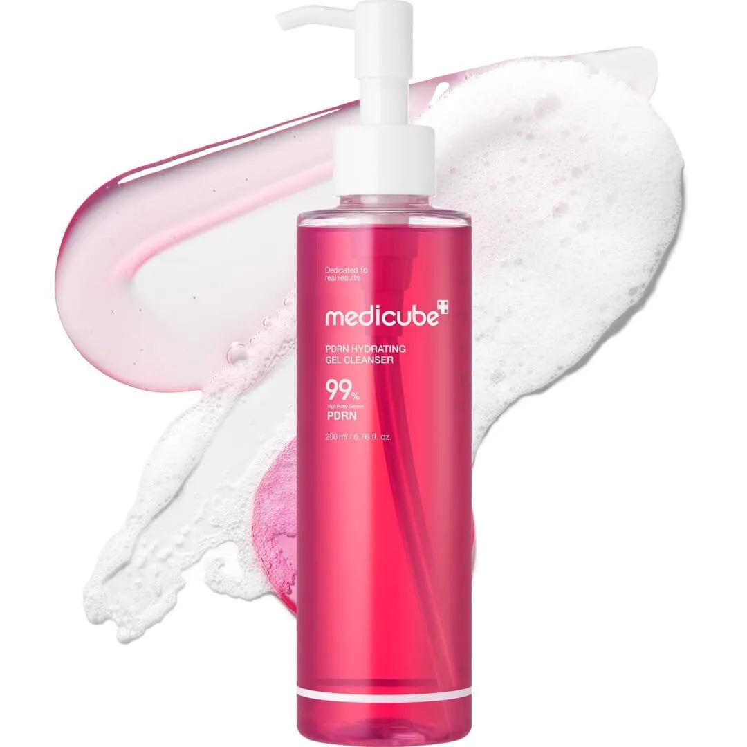 Pink bottle of Medicube cleanser with pump and foam on a white background