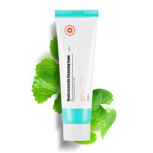 Tube of skincare product with green leaves on a white background