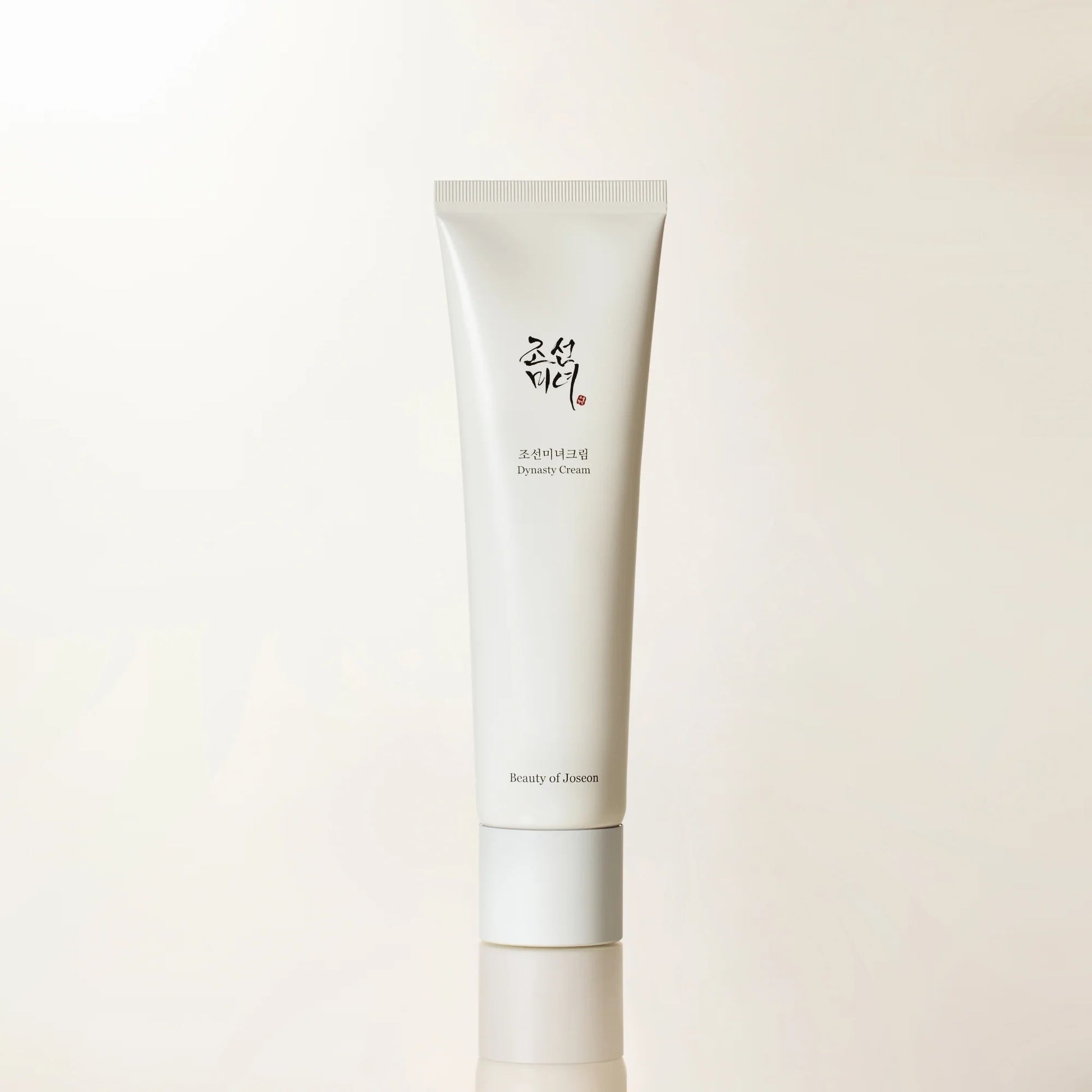 Skincare cream tube with brand logo on a light beige background