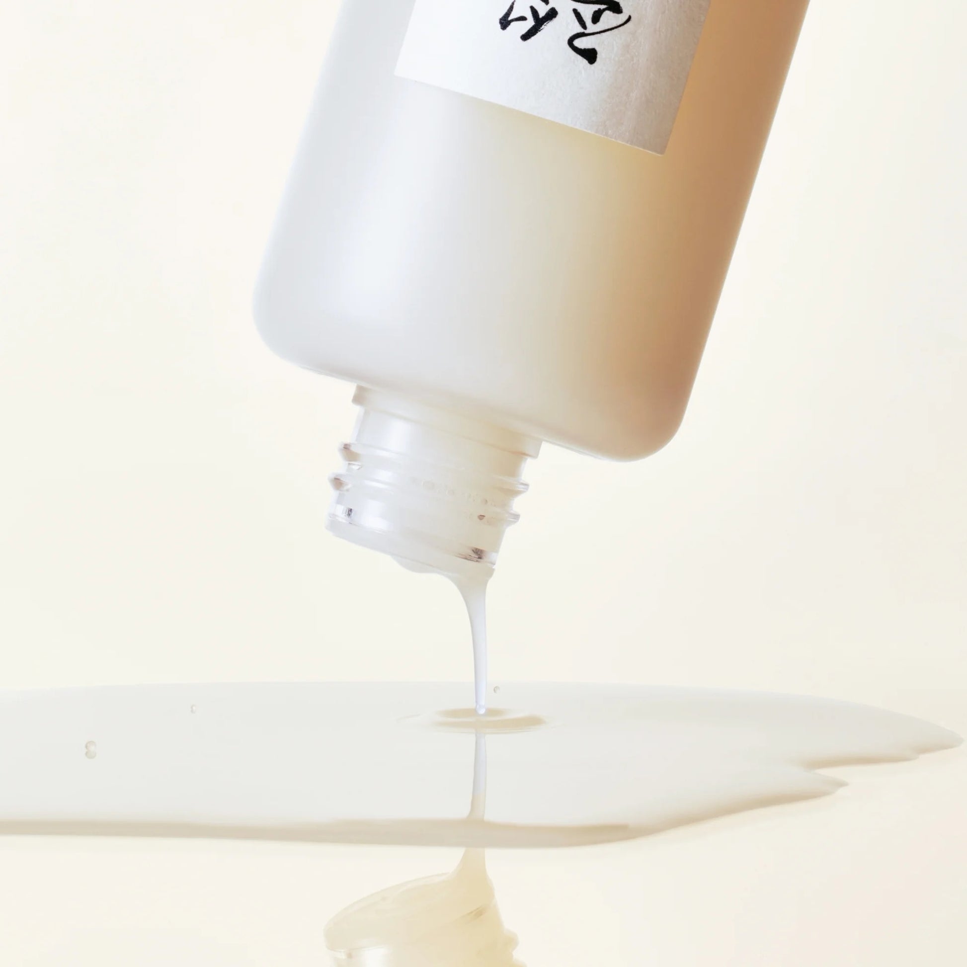 Close-up of a bottle cap being removed from a tube, with a brand name visible.