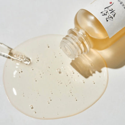 Skincare serum bottle with dropper and gel on a white background