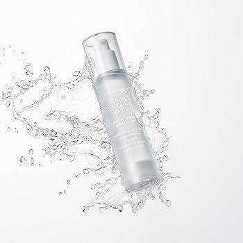 Clear skincare bottle with water droplets on a light gray background