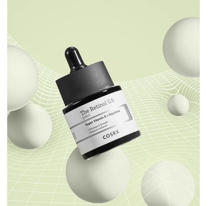 Cosrx skincare serum bottle on a green background with geometric shapes